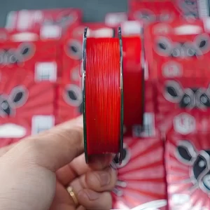 Cận cảnh sợi dù câu lure LK RED X8 mịn màng trên tay, thể hiện kết cấu bện 8 lõi tròn đều và chắc chắn