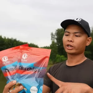 Cần thủ Hòa LK đang cầm và giới thiệu bao bì mồi câu cám chép LK phiên bản túi đỏ mới nhất