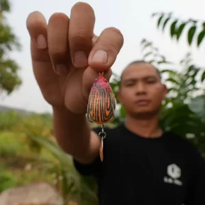 Cận cảnh mồi câu lure Bọ LK màu cam trên tay cần thủ